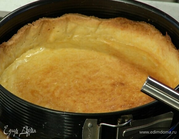 Выстелить дно разъемной формы бумагой для выпечки, выложить тесто и сформировать бортики, сверху накрыть бумагой, засыпать любыми бобовыми и отправить в разогретую духовку на 20 минут, затем корж остудить.