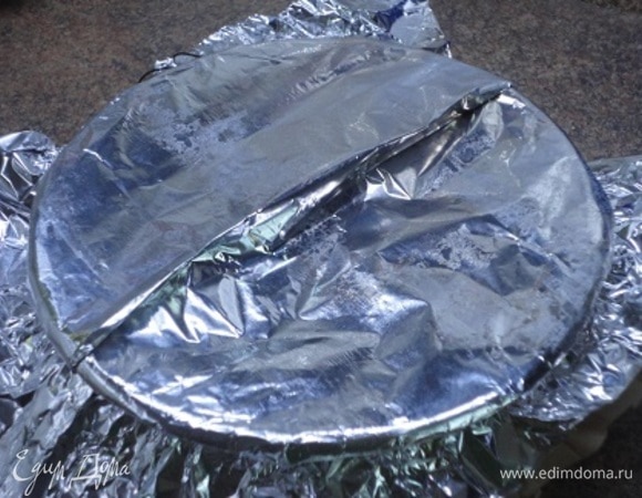 Отрежьте кусок пекарской бумаги и алюминиевой фольги размером, достаточным для покрытия формы сверху и свисающим на половину высоты формы. Сложите вместе бумагу и фольгу и заложите складку, проходящую через центр. Это надо для того, чтобы у пудинга было место для подъема. Накройте форму для пудинга и плотно завяжите по краю жгутом.