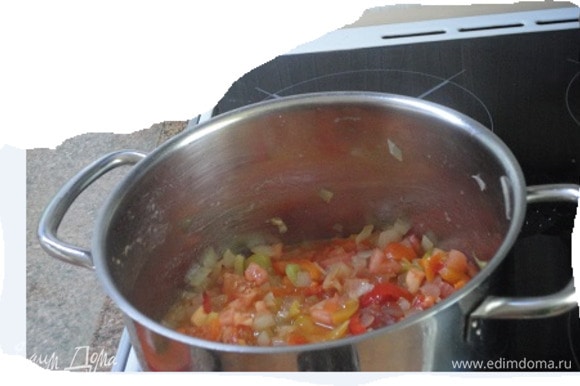 Мясо вынуть. В том же жире обжарить лук до прозрачности, потом добавить перец, помидоры, томатную пасту, посыпать тимьяном и тушить 7 минут. Вернуть мясо в кастрюлю, влить бульон. Довести до кипения, убавить нагрев и готовить 20 минут до полной готовности индейки.