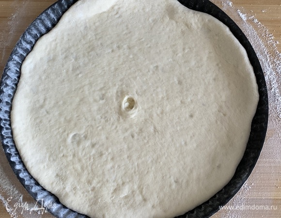 Посыпая немного мукой, разравниваем до толщины 5–10 мм. Чем тоньше, тем вкуснее. В середине делаем отверстие. Форму посыпаем мукой, выкладываем пирог.