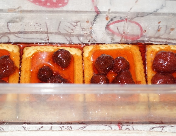 На каждое печенье положите по 4 ягодки и залейте первый ряд клубничным сиропом из варенья.