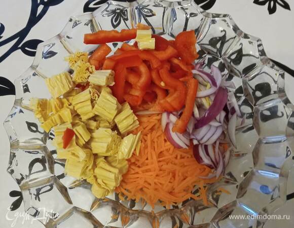 Готовую спаржу тщательно промываем, обсушиваем и нарезаем кубиком. Морковь трем на терке для корейской моркови или на обычной. Лук режем перьями, сладкий перец — полосками.