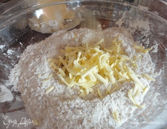 Смешиваем муку, разрыхлитель и соль. Холодное масло натираем на терке и перетираем все руками быстро в масляную крошку.