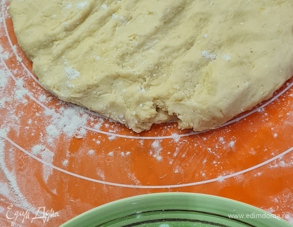 Изюм и цукаты замачиваем в роме. Масло комнатной температуры взбиваем с сахаром до кремового состояния. Вводим яйца, взбиваем. Добавляем измельченный творог, ванильный сахар, сок и цедру лимона. Добавляем муку, соль, разрыхлитель, размешиваем лопаткой, затем на столе, посыпанном мукой, месим руками. Тесто должно быть мягким и не прилипать к рукам.