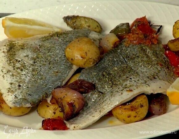 Петрушку и укроп порезать, посыпать рыбу с овощами и подавать с нарезанным дольками лимоном.