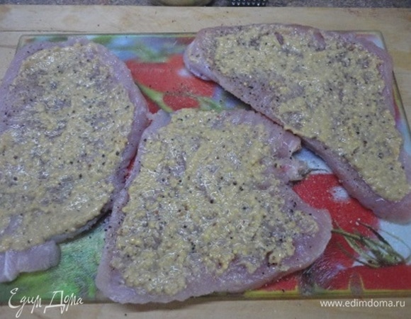 Мякоть индейки нарежьте на стейки. Посолите, поперчите и одну сторону каждого кусочка смажьте 1 ч. л. горчицы. 