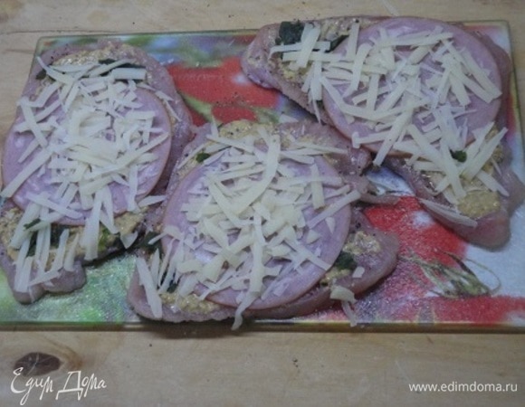 Посыпьте сыром и сверните стейки в рулетики, после чего закрепите их.