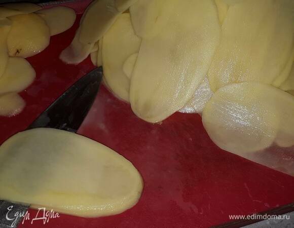 Картофель очистите, срежьте боковые части и нашинкуйте в длину тонкими пластинками по 2–3 мм толщиной. Может показаться, что это долго, но с острым ножом можно управиться за 15 минут. 