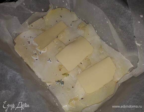 На дно формы для запекания выложите пекарскую бумагу (чтобы она закрывала бортики). Положите на дно 2–3 кубика масла. Окуните каждый кусочек картофеля в сливки и выложите на дно в 2–3 слоя. Посыпьте давленым чесноком, положите еще несколько кубиков масла и влейте 2–3 ст. л. сливок. Продолжите утрамбовывать картофель, чередуя с маслом и чесноком каждые 2–3 слоя картофеля.