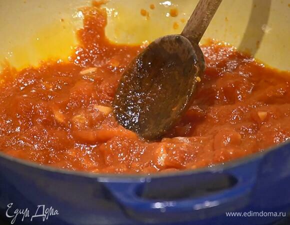 Разогреть в тяжелой кастрюле оливковое масло и обжарить чеснок до прозрачности, добавить томатную пасту, хлопья чили и все перемешать, затем выложить помидоры в собственном соку, всыпать сахар и, помешивая, прогреть.