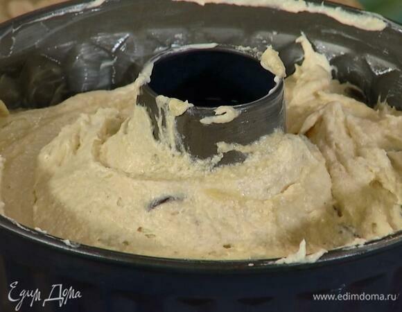 Круглую форму для кекса с выемкой посередине смазать оставшимся сливочным маслом и выложить тесто.