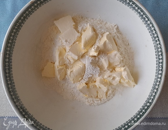 Муку просеять. В муку нарезать кусочками холодное сливочное масло. Одно яйцо разделить на белок и желток.