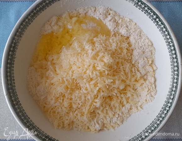 В масляно-мучную крошку добавить сыр, яичный белок, соль.