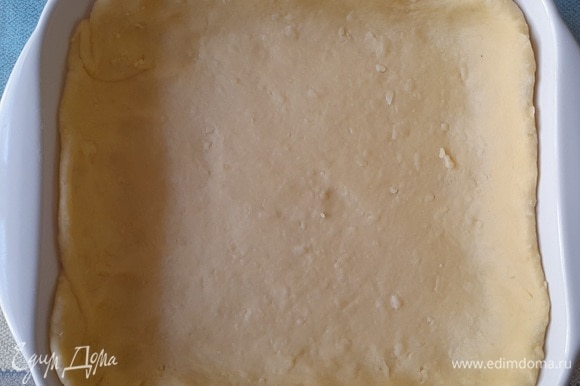 Форму смазать холодным сливочным маслом. Выложить тесто в форму, формируя бортики.