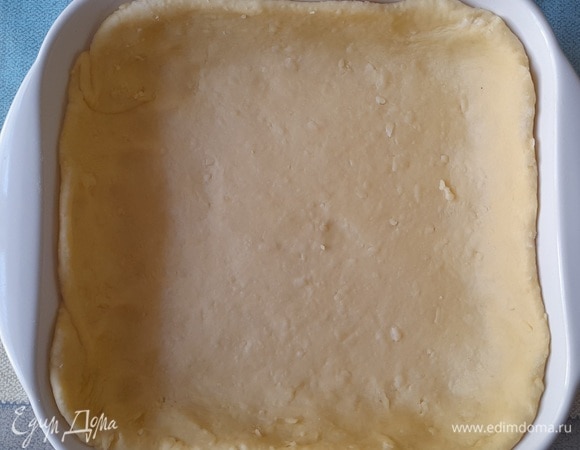Форму смазать холодным сливочным маслом. Выложить тесто в форму, формируя бортики.
