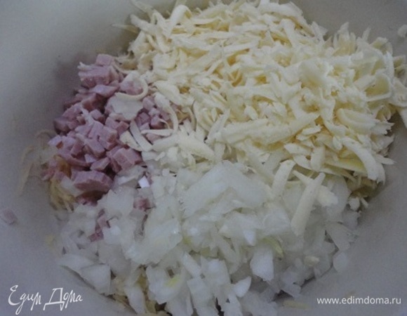 Добавить нарезанные мелкими кубиками лук и бекон, натертый на крупной терке сыр.
