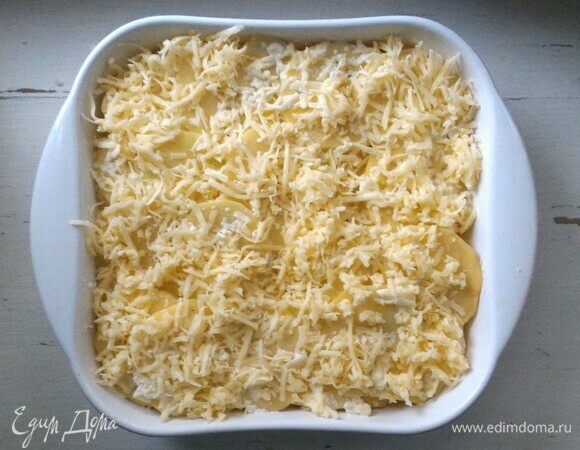 Сверху засыпать картофель отложенным сыром. Поставить форму в духовку, предварительно разогретую до 200°С, на 40–45 минут.