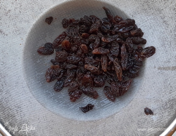 Изюм выложить на сито и тщательно промыть под проточной водой, чтобы удалить мелкие соринки и песок.