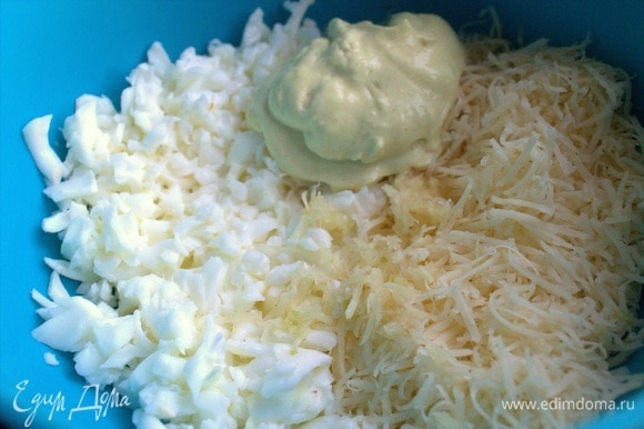 В белки добавить тертый сыр и смешать с ложкой того же майонеза. По желанию выдавить чеснок в этот слой.