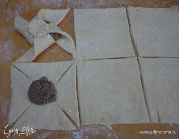 Включить духовку разогреваться до 200°C. Тесто разделить на две части и каждую выложить на посыпанную мукой доску, раскатать в пласт 1/3 см толщиной. Разрезать на 6 квадратов со стороной 10 см и 6 маленьких кружочков. Каждый угол квадрата надрезать по направлению к центру (примерно 4 см). на середину квадрата выложить начинку. 4 угла соединить в центре, чтобы получилась вертушка, сверху скрепить кружком.
