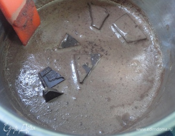 Поместите ковш на плиту со средним нагревом, продолжая мешать. Добавьте кусочки шоколада. Продолжайте мешать, пока шоколад не растопится, но напиток не закипит. Подсыпайте крахмал, перемешивайте.