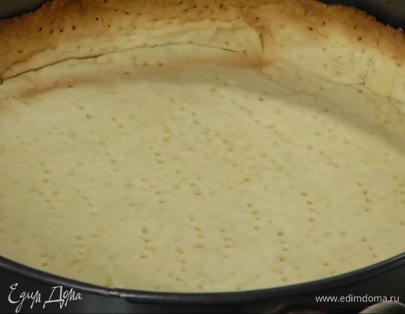 Часто наколоть тесто вилкой, накрыть бумагой для выпечки, засыпать любыми бобовыми и выпекать в разогретой духовке 15 минут.