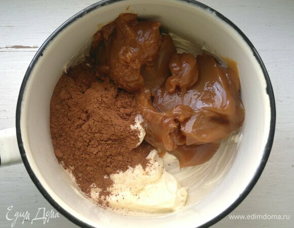 Для масляного крема соедините вареное сгущенное молоко, размягченное сливочное масло, какао, взбейте до однородности. При помощи силиконовой лопатки смажьте верх и бока торта кремом. Верх делайте как можно ровнее, а на боках имитируйте кору дерева (неровности) с помощью чайной ложки. Поставьте торт в холодильник еще на 1–2 часа для застывания масляного крема. Потом достаньте его и с помощью деревянной палочки нарисуйте сверху «годовые кольца» сгущенным молоком.