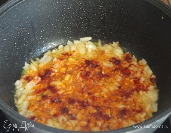 На время выложите кусочки птицы из сотейника, а в оставшемся жире обжарьте мелко нарезанные лук с чесноком и посыпьте паприкой.