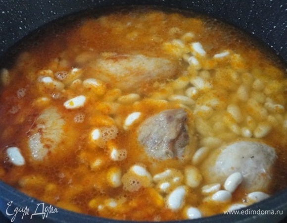 С фасоли слейте воду и выложите ее вместе с птицей на луковую основу. Налейте горячую воду, чтобы она покрывала мясо с фасолью. Доведите все до кипения, посолите, поперчите и готовьте под крышкой на медленном огне примерно 1 час 10 минут. Индейку немного подольше, почти 1,5 часа. За это время мясо станет мягким.