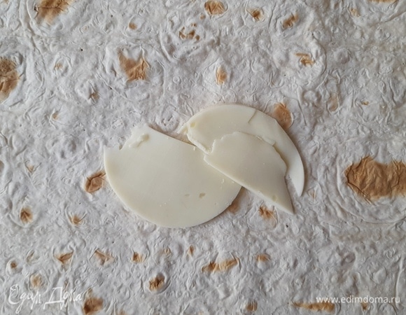 Посередине листа лаваша выложить кусочки моцареллы.