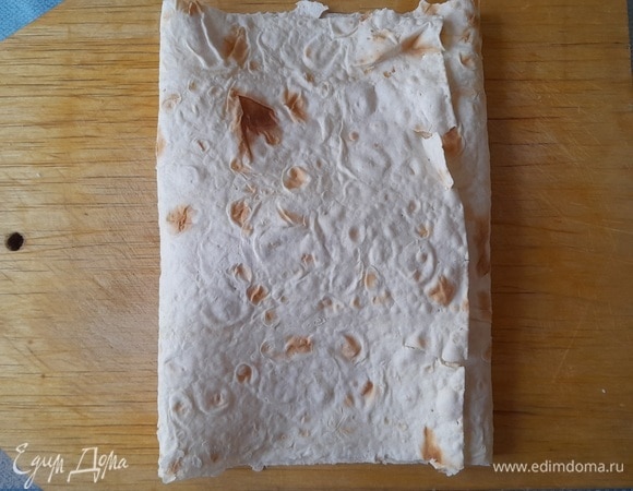 Закрыть начинку боковыми краями лаваша, положив их внахлест друг на друга.