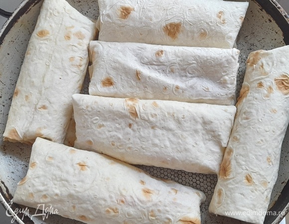 В сковороде разогреть растительное масло. Выложить трубочки из лаваша. Обжарить сначала с одной стороны.