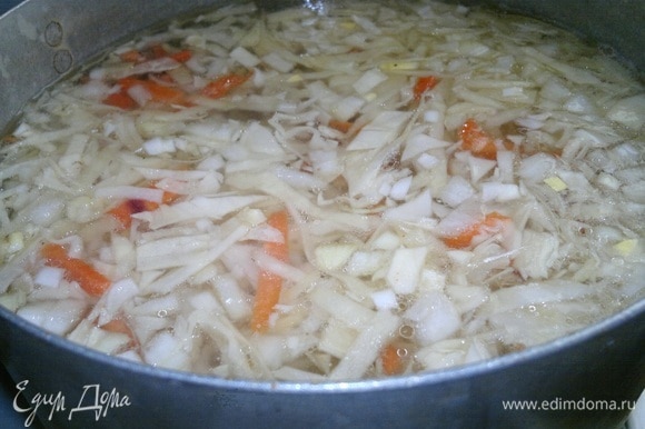 Добавить нарезанные морковь и лук в кастрюлю, продолжать варить до готовности капусты и овощей.