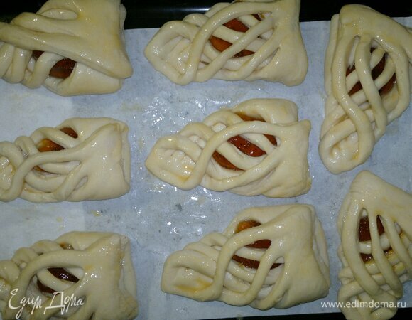 Подошедшие слойки выложить на противень с пергаментом, смазанным растительным маслом. Смазать яйцом, стараясь не затрагивать срезы.