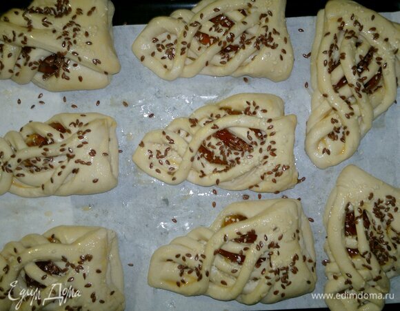 Посыпать слойки семенами льна и кунжута. Поставить противень с заготовками в духовку, разогретую до 210°C, сначала на 5 минут. Затем снизить температуру до 180°C и продолжать выпекать 20–25 минут.