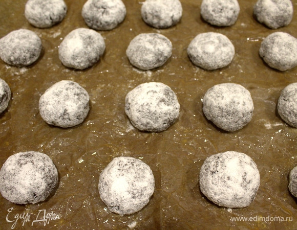 Перенести шарики на бумагу для выпечки, слегка приплюснуть.