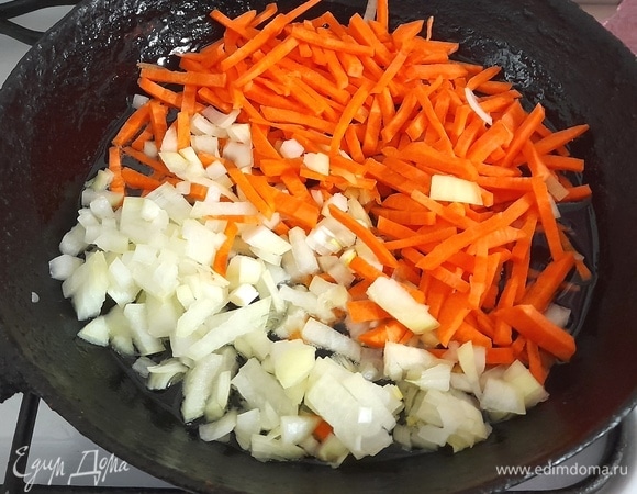 Лук и морковь почистить, вымыть, обсушить. Морковь нарезать соломкой, лук — мелкими кубиками. В глубокой сковороде разогреть растительное масло, выложить лук с морковью и обжарить овощи, помешивая, до мягкости и легкого румянца.