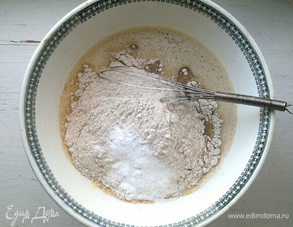 Порциями добавить просеянную муку с содой, тщательно размешать. Тесто сначала будет густым.