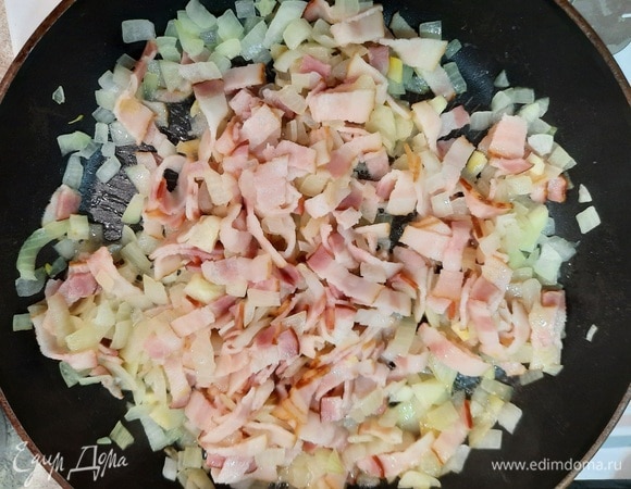 Очистите картофель, положите его в холодную воду и отварите в течение 20 минут. Откиньте на дуршлаг и остудите. Нарежьте картофель ломтиками. Обжарьте лук в половине сливочного масла в течение 10 минут. Мелко нарежьте бекон, добавьте его к луку и готовьте еще 5 минут.