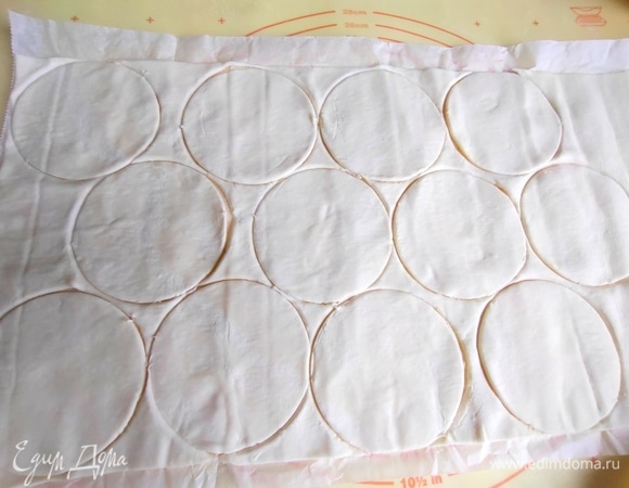 Замороженное слоеное тесто переложить с вечера в холодильник. Раскатать, вырезать кружочки диаметром 9 см.