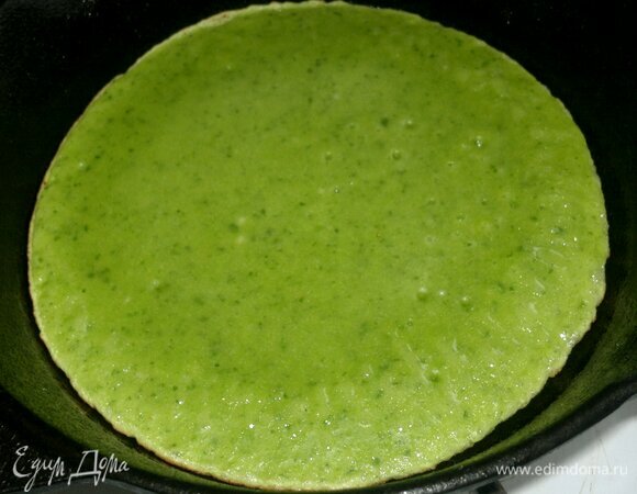 Выпекать блинчик на умеренном огне с одной стороны. Дождаться, когда тесто на верхней части блинчика полностью высохнет. Снять блинчик со сковороды и выложить на блюдо. Испечь все блинчики. До подачи сохранять в тепле.