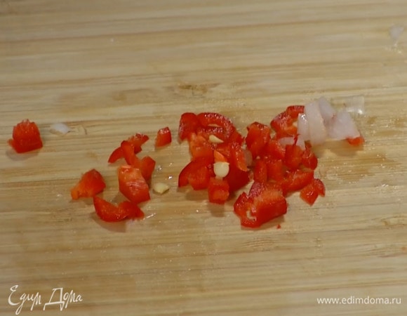 Перец чили мелко порезать, добавить к луку с чесноком и перемешать.
