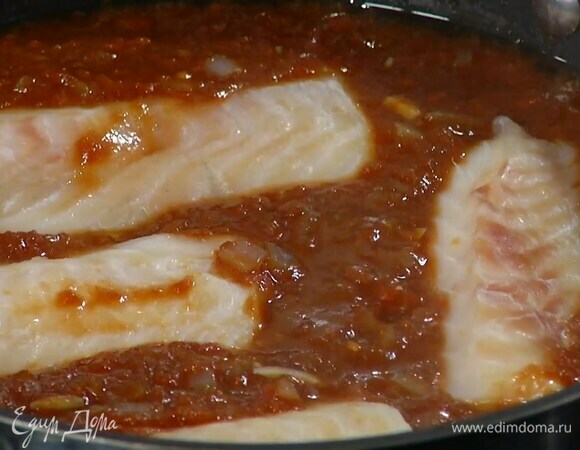 Филе трески выложить сверху на соус, посолить, поперчить, убавить огонь, накрыть крышкой и томить 10–12 минут до готовности рыбы.