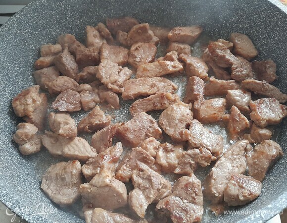 На сковороде разогреть часть растительного масла, выложить свинину и обжарить почти до готовности. Выложить мясо в тарелку, масло оставить в сковородке.