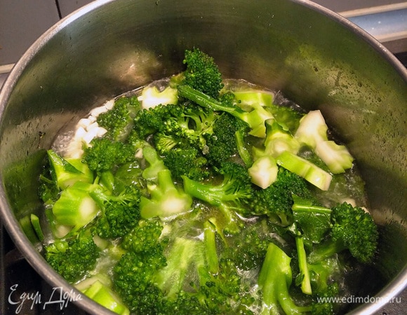 Добавляем воду в кастрюлю с брокколи так, чтобы вода не покрывала целиком всю эту овощную массу. Мешаем, тушим.