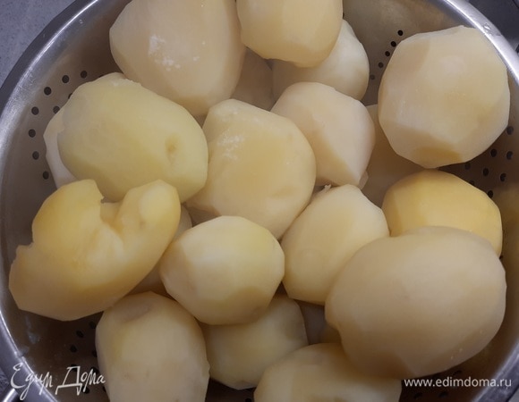 Разогрейте духовку до 180°C. Откиньте картофель на дуршлаг и нарежьте его ломтиками. Разрежьте сыры пополам по толщине.