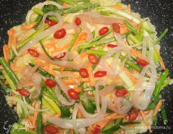 В сковороде разогреть растительное масло. Половником выложить смесь максимально тонким слоем. Хорошенько примять и выровнять. У меня из этого количества получается два блина, но все зависит от сковородки. Мясо кальмара и перец разделить на количество блинов и выложить сверху. Накрыть крышкой и жарить на среднем огне минуты 2–3. Проверить низ блина. Если поджарился, аккуратно перевернуть. Затем накрыть крышкой и прожарить вторую сторону, снять со сковороды. Теперь можно жарить следующий блин. Повторить весь процесс еще раз. Перед жаркой хорошенько перемешать овощи в тесте, потому что оно имеет свойство оседать на дно. 