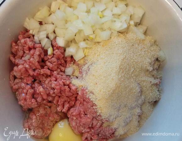 Для фрикаделек смешиваем свиной фарш с мелко нарезанным луком, яйцом и панировочными сухарями. Добавляем черный перец и немного соли. Вымешиваем фарш.