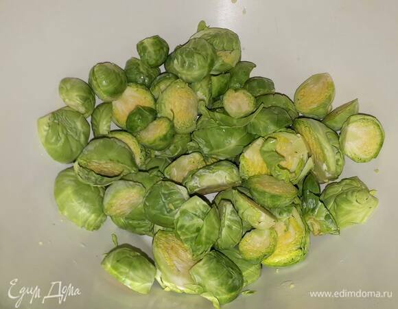 У брюссельской капусты отрежьте ножки, удалите жухлые верхние листья и разрежьте пополам.