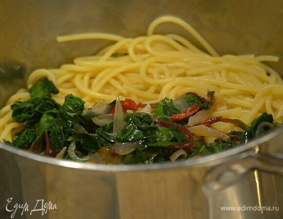 Вернуть спагетти обратно в кастрюлю, добавить обжаренную зелень, поместить все на огонь, влить немного сохраненной воды и перемешать.